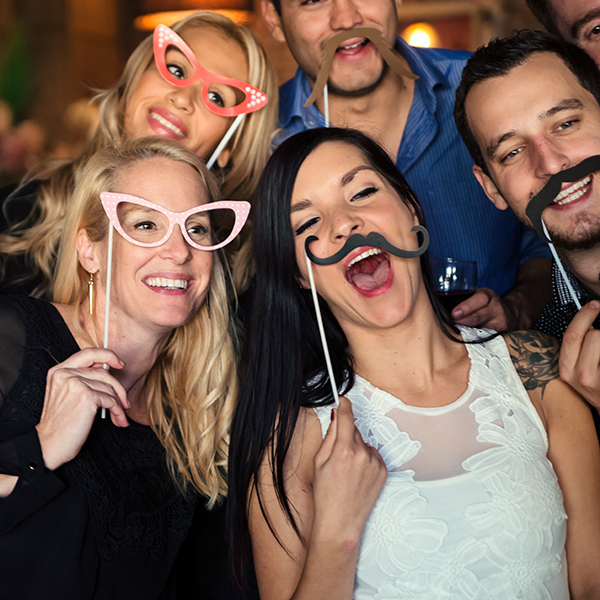 People having fun with photo booth accessories taking selfies